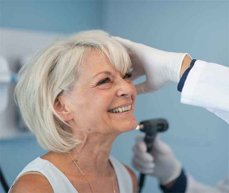 Woman having her ears examined by a hearing expert